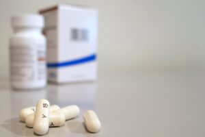 Prescription medication capsules and pill bottle representing ADAP medication access